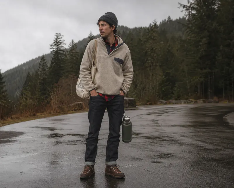 Pacific Northwest outdoor casual: oatmeal Snap-T fleece, red buffalo-check flannel, raw denim, Danner boots, beanie, Stanley thermos.